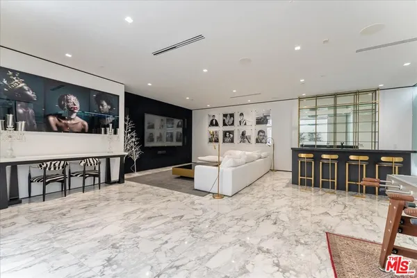 a living room with furniture a flat screen tv and floor to ceiling window