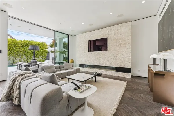 a living room with couches a flat screen tv and a large window