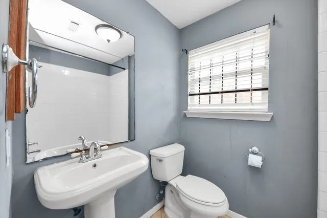 a bathroom with a sink a toilet and mirror