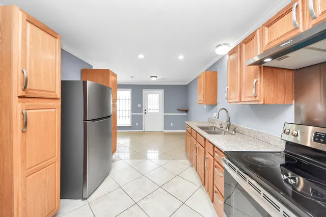 a kitchen with stainless steel appliances granite countertop a refrigerator a sink and a stove