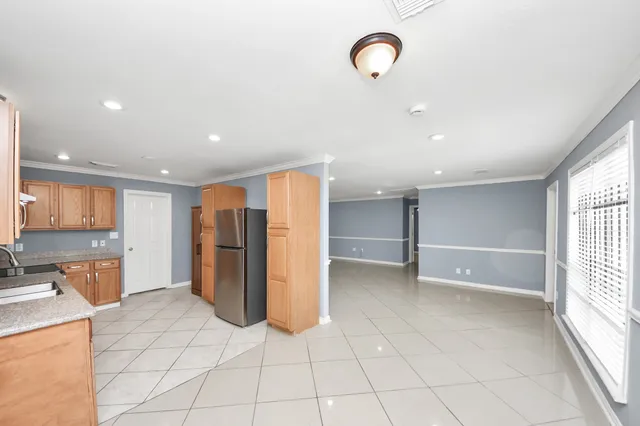 a view of kitchen with refrigerator and cabinets