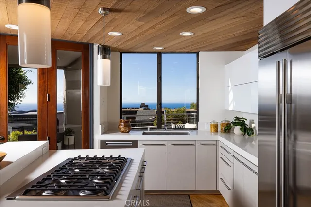 a kitchen with stainless steel appliances a stove refrigerator and sink