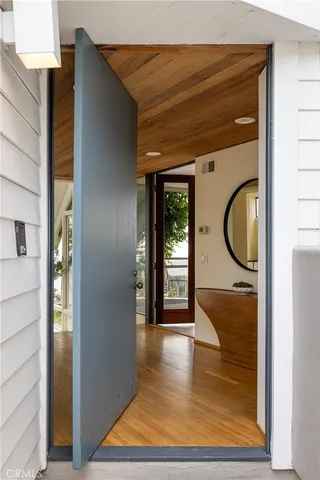 a view of a hallway with wooden floor and glass door