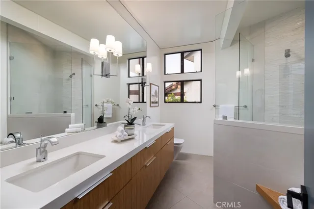 a bathroom with double vanity sinks a mirror a vanity and a bathtub