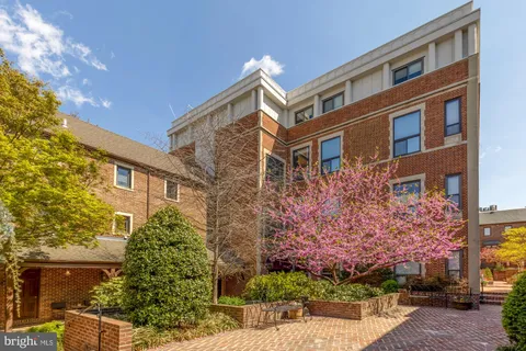 a front view of a multi story residential apartment building with a yard
