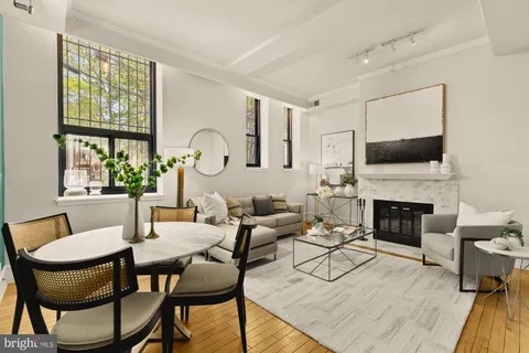 a living room with furniture a fireplace and a large window