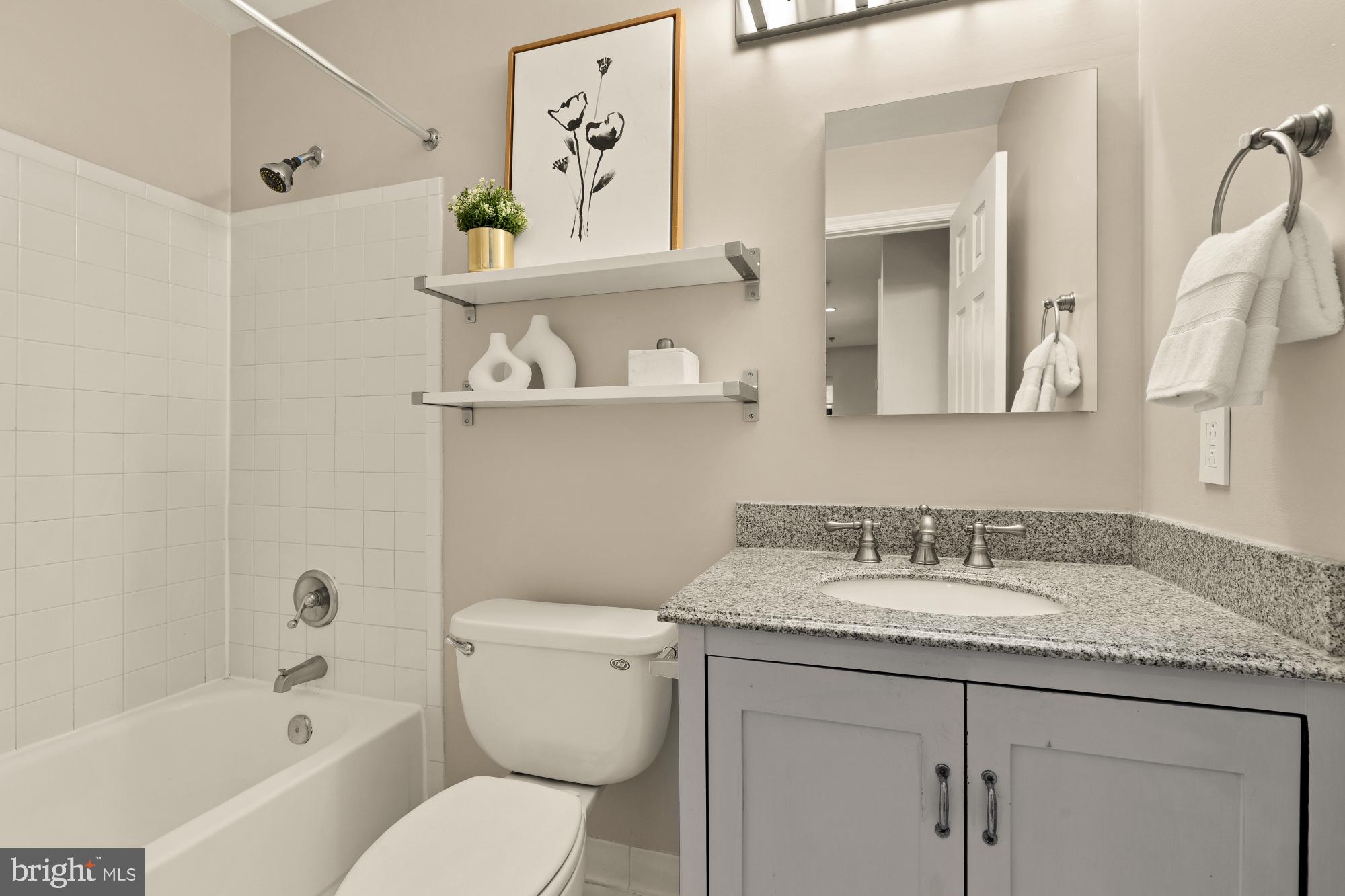 1715 15th Street Northwest, Unit 101 Washington, DC 20009 - Photo 9 of 24 a bathroom with a granite countertop toilet sink and mirror