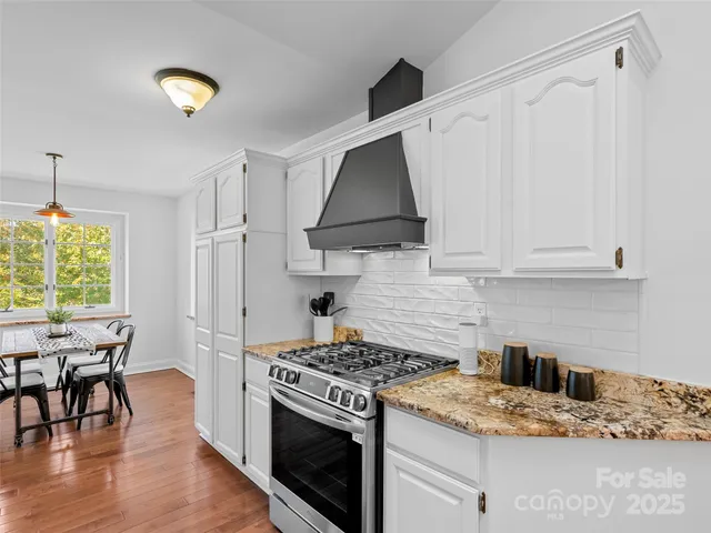 a kitchen with a stove and a white cabinets
