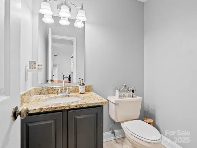 a bathroom with a granite countertop toilet sink and mirror