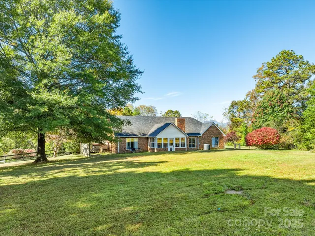 a view of a house with a big yard and large trees