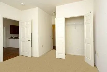 a view of an empty room with closet and wooden floor