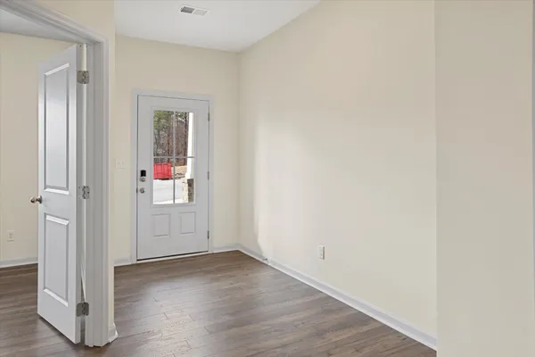 an empty room with wooden floor and windows
