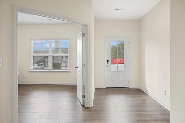 an empty room with wooden floor and windows