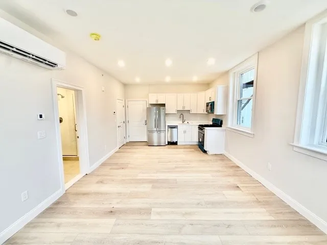 a view of a kitchen with wooden floor and a window