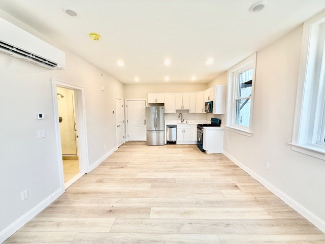 a view of a kitchen with wooden floor and a window