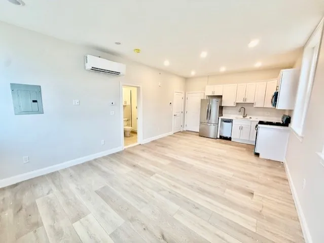 a view of a kitchen with furniture and wooden floor