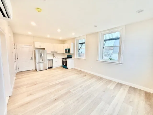 a view of empty room with a kitchen