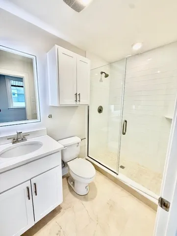 a bathroom with a sink a toilet and shower