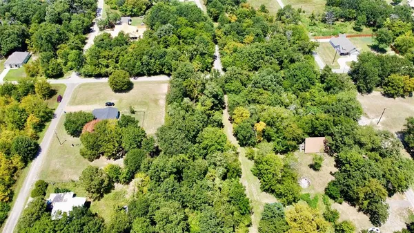 an aerial view of residential house with outdoor space and trees all around