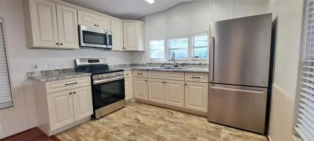 a kitchen with a refrigerator stove and sink
