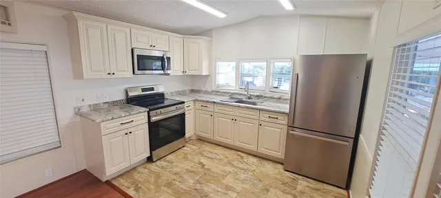 a kitchen with white cabinets and refrigerator