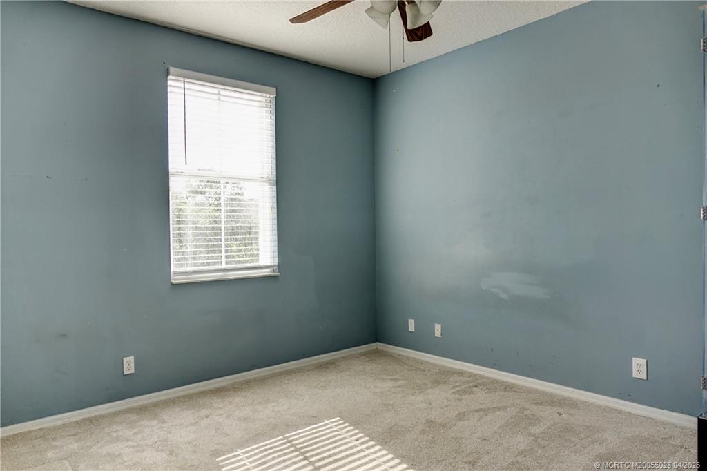 2120 Northwest Marsh Rabbit Lane Jensen Beach, FL 34957 - Photo 29 of 34 an empty room with a window and a ceiling fan