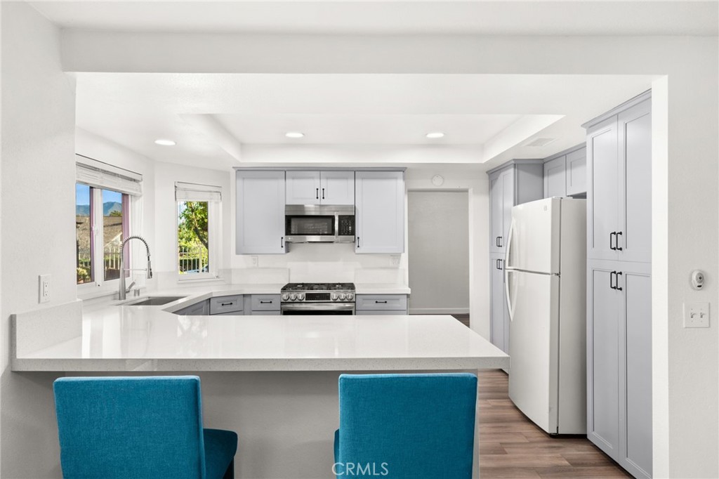 162 Lakeside Avenue Redlands, CA 92373 - Photo 10 of 32 a kitchen with stainless steel appliances a sink a stove a refrigerator and cabinets