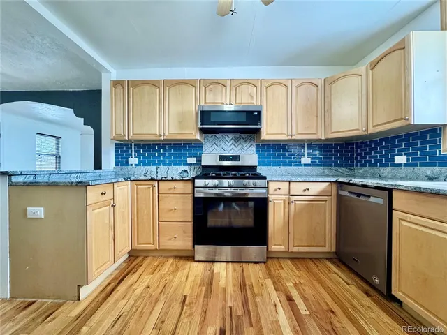 a kitchen with granite countertop a stove top oven sink and cabinets