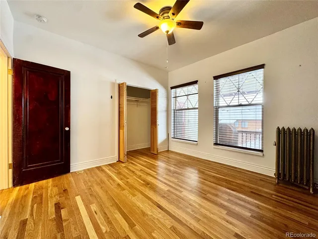 a view of an empty room with a window and a chandelier fan