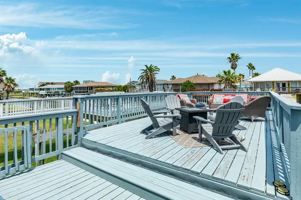 a balcony with wooden floor table and chairs