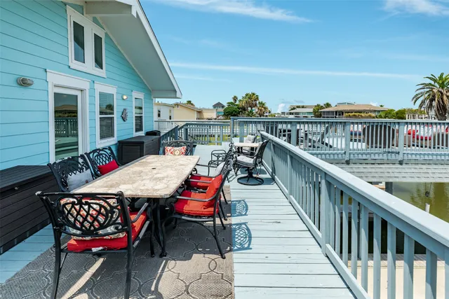 a backyard of a house with wooden floor and outdoor seating