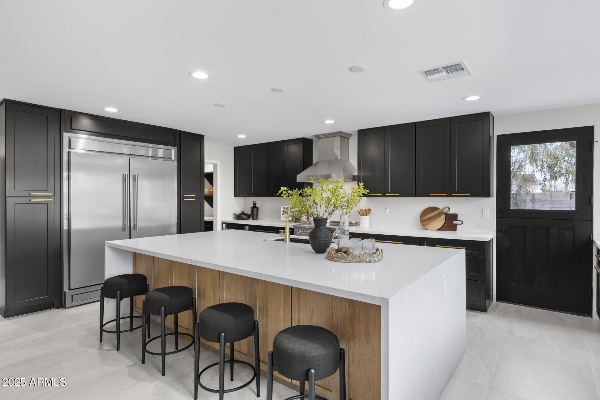 4059 East Cholla Street Phoenix, AZ 85028 - Photo 24 of 70 a kitchen with stainless steel appliances a dining table chairs refrigerator and cabinets