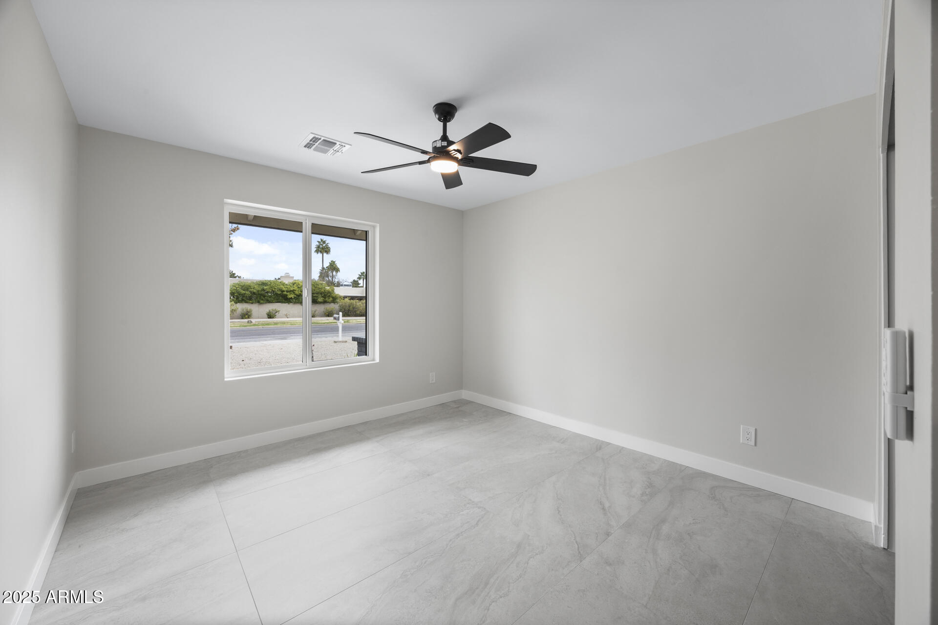 4059 East Cholla Street Phoenix, AZ 85028 - Photo 45 of 70 an empty room with a window and a ceiling fan