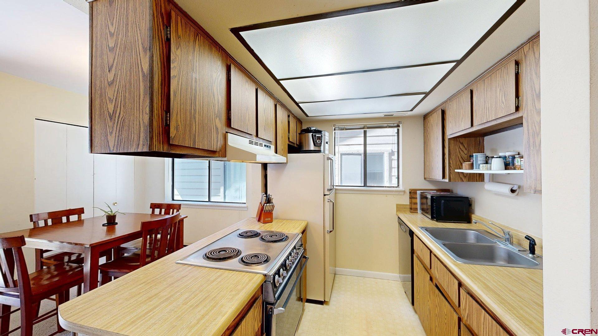 1200 Florida Road, Unit 52 Durango, CO 81301 - Photo 8 of 29 a kitchen that has a microwave a stove and a table in it
