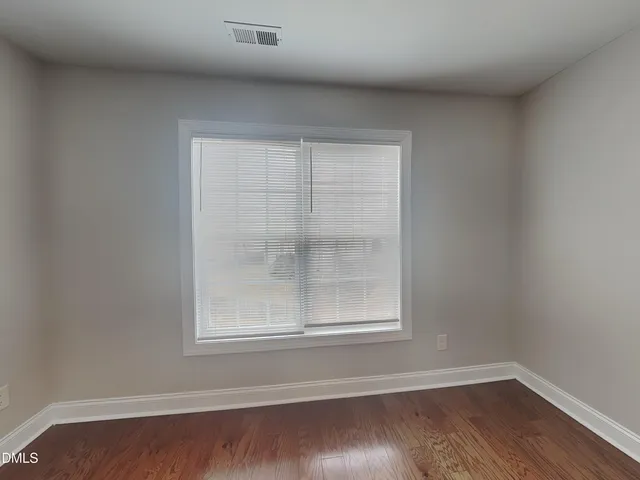 a view of a small space with wooden floor and a window