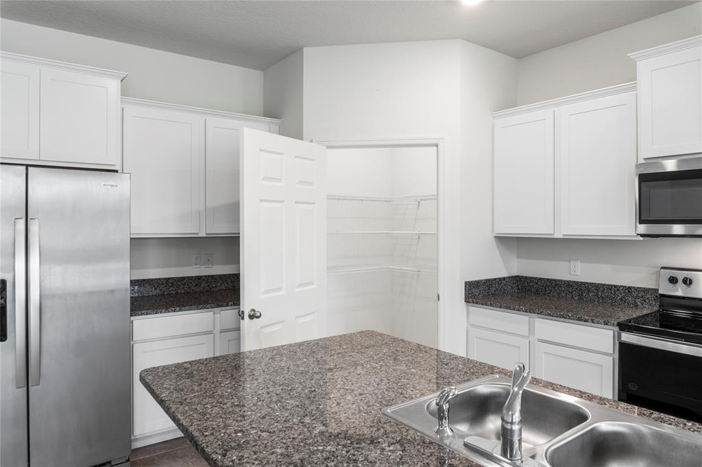 2025 Amazon Way Vero Beach, FL 32962 - Photo 11 of 33 a kitchen with stainless steel appliances granite countertop a sink stove and refrigerator