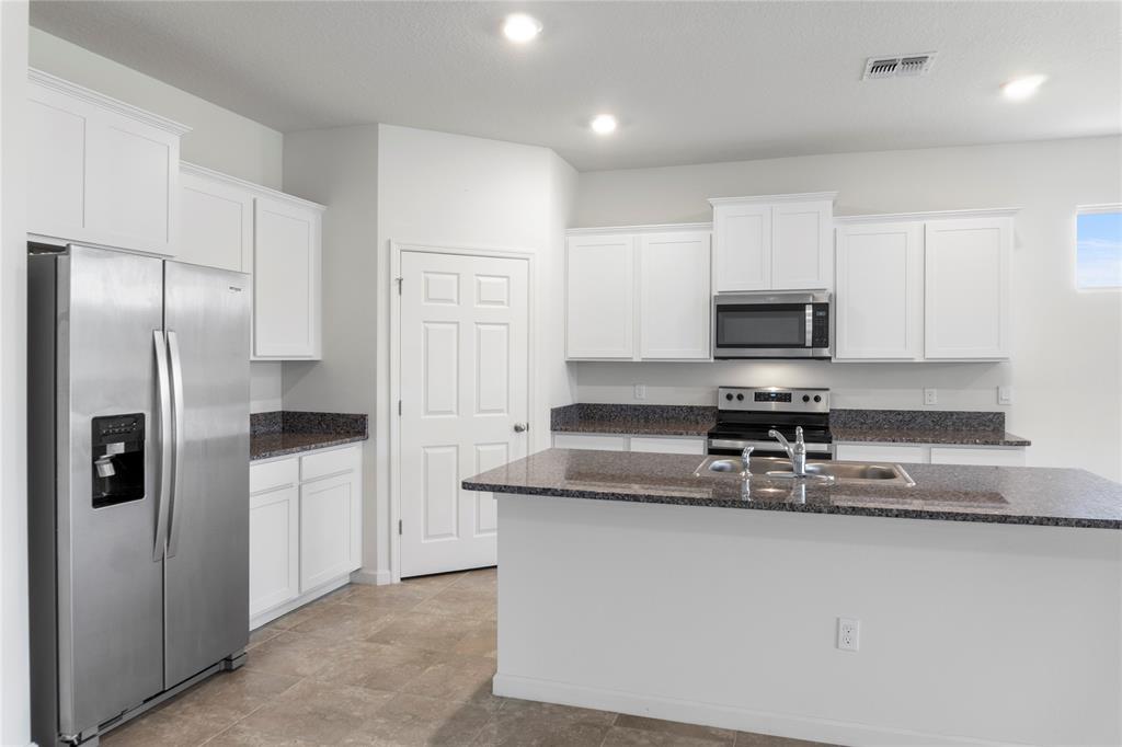 2025 Amazon Way Vero Beach, FL 32962 - Photo 10 of 33 a kitchen with stainless steel appliances granite countertop a refrigerator a stove and a sink