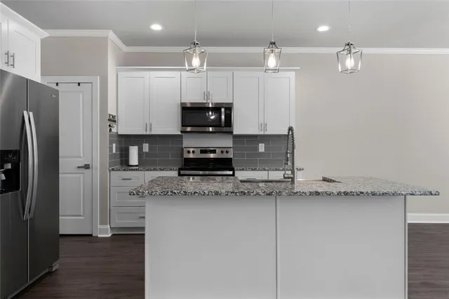 a kitchen with stainless steel appliances granite countertop a refrigerator and a stove top oven