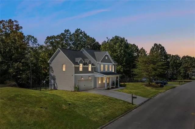 a front view of a house with a garden and yard
