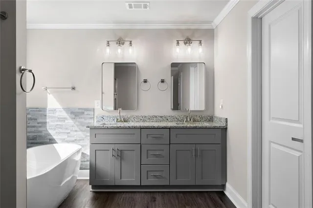 a bathroom with a granite countertop sink a large mirror and a bathtub