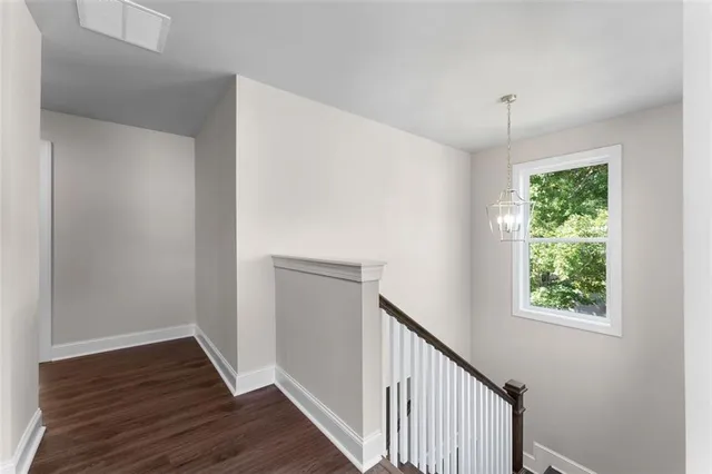 a view of a hallway with wooden floor and a window