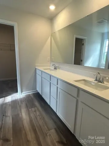 a bathroom with double vanity sink and a mirror
