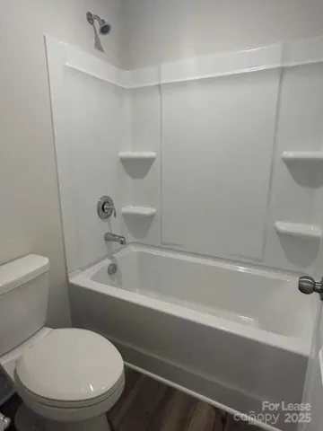 a white toilet sitting next to a bath tub