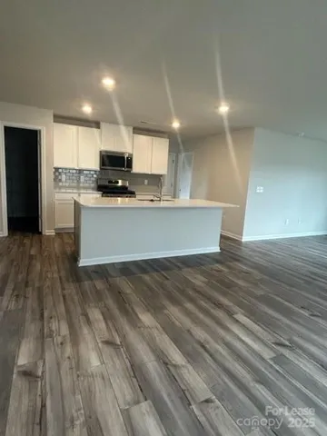 a view of kitchen with granite countertop cabinets and refrigerator