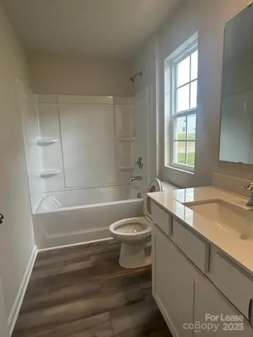 a bathroom with a sink toilet vanity and bathtub