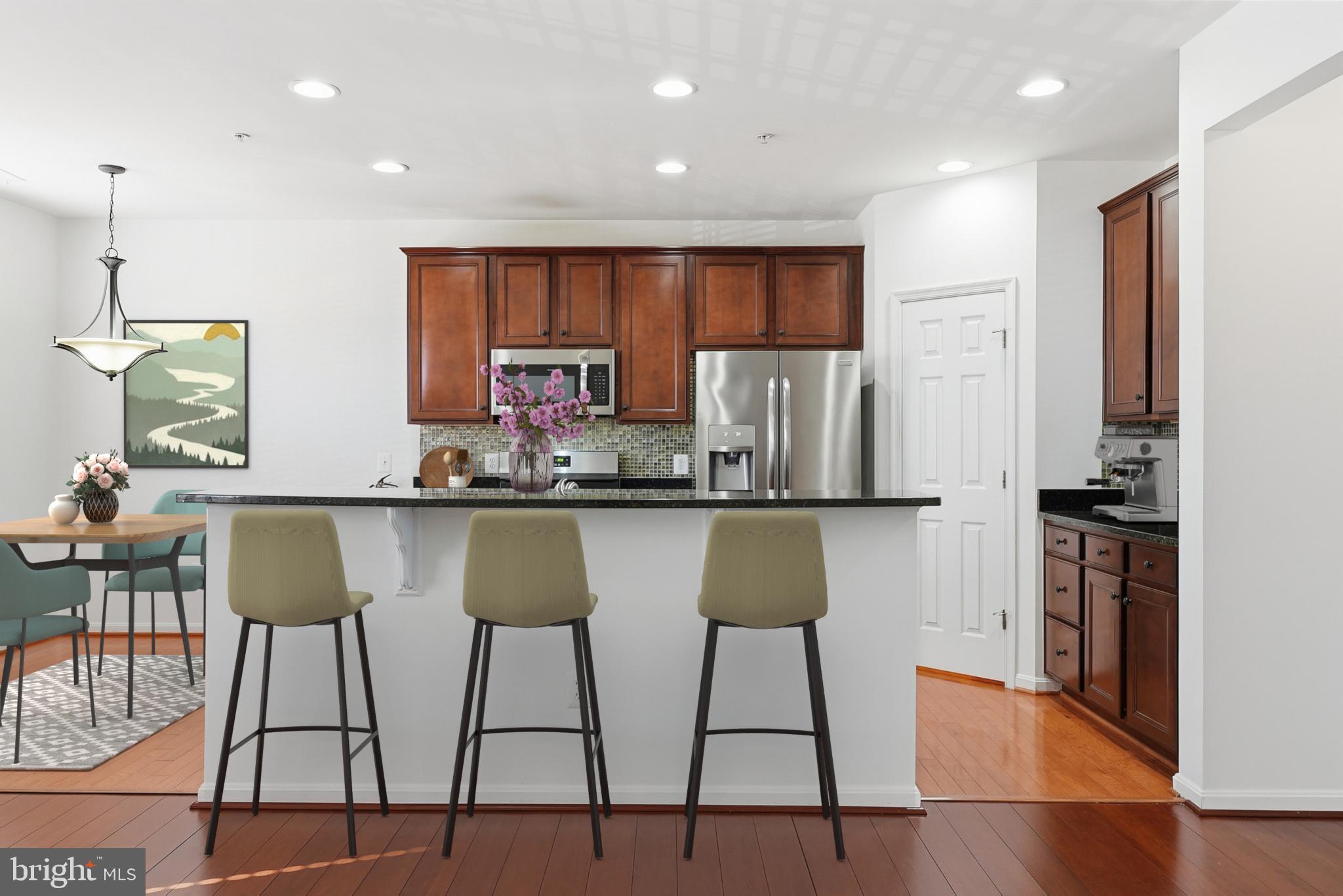 9539 Center Street Manassas, VA 20110 - Photo 14 of 41 a kitchen with stainless steel appliances kitchen island granite countertop a table chairs refrigerator and sink