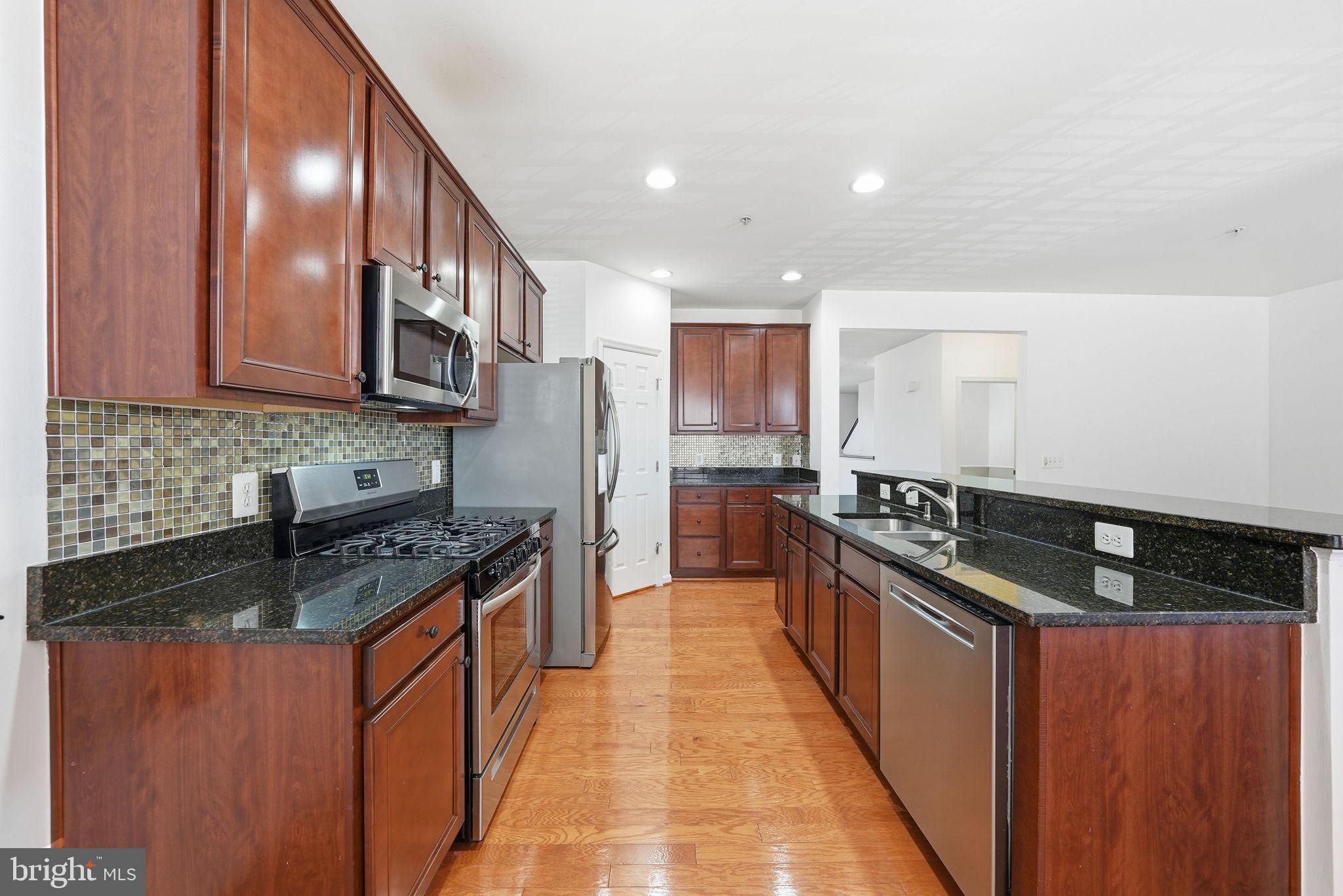9539 Center Street Manassas, VA 20110 - Photo 15 of 41 a kitchen with stainless steel appliances granite countertop a stove a sink and a refrigerator