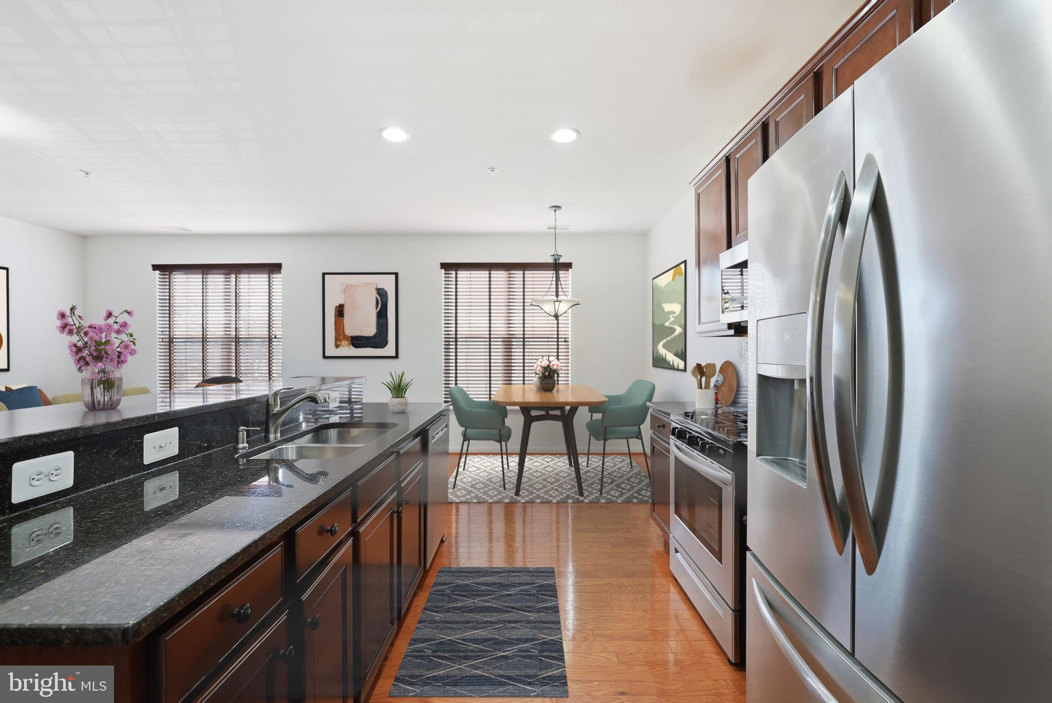9539 Center Street Manassas, VA 20110 - Photo 19 of 41 a kitchen with stainless steel appliances granite countertop a refrigerator a sink dishwasher a dining table and chairs with wooden floor