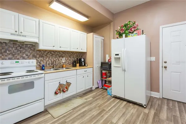 a kitchen with refrigerator and cabinets