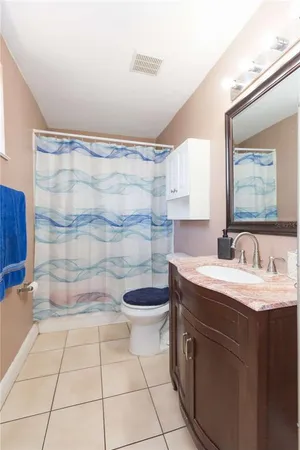 a bathroom with a granite countertop sink a toilet and a shower